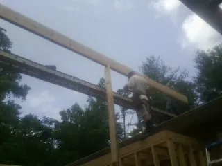Carpenter setting a ridge beam over a new addition frame — Ice Dam Removal by Roofing Brothers in Rock Creek