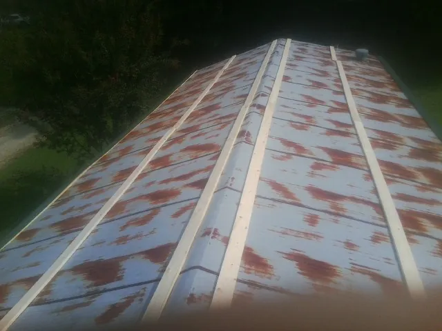 Rusted metal roof panels with new wood purlins before replacement — Storm Damage Roof Repair in Rock Creek by Roofing Brothers