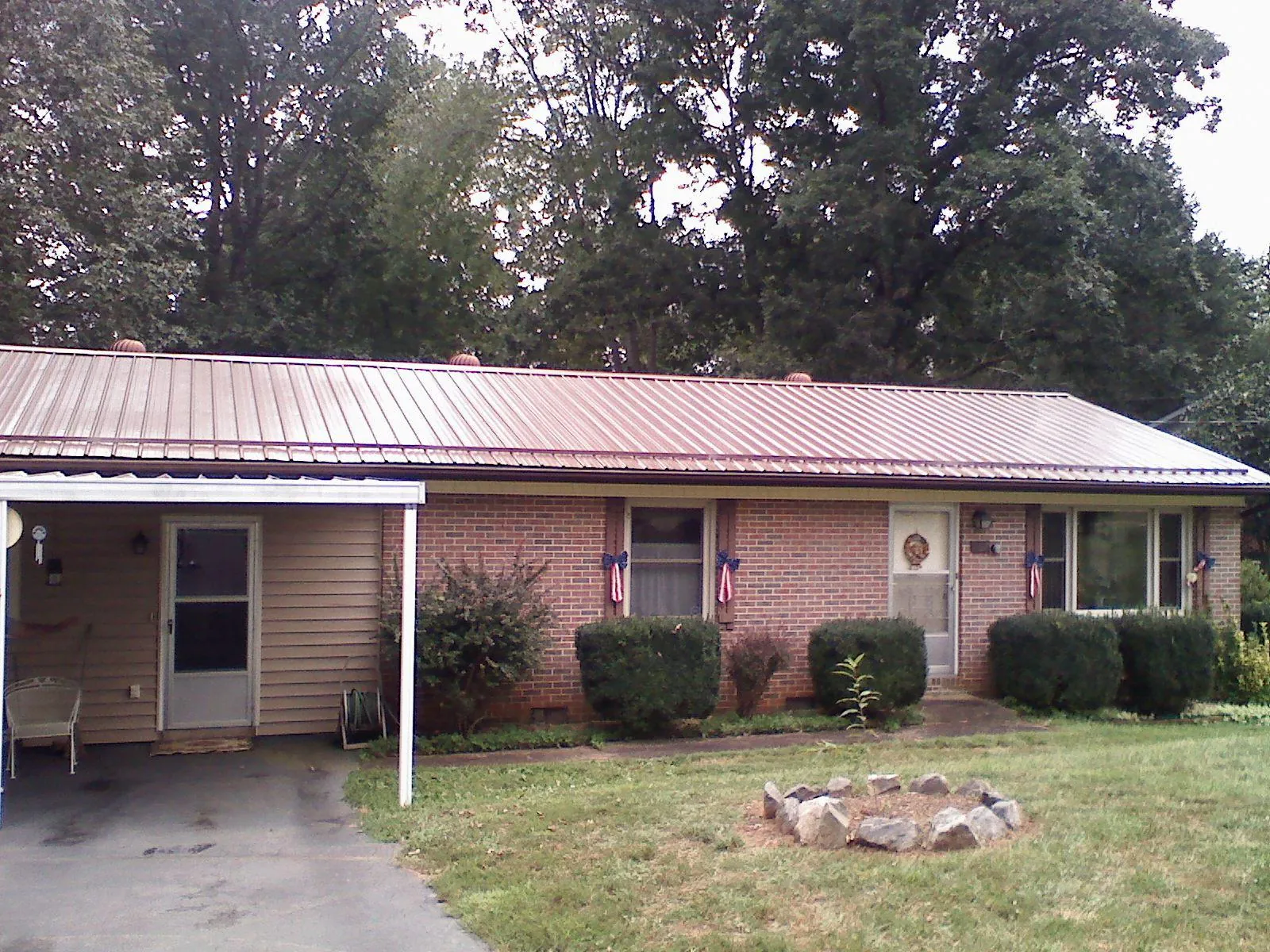 Bronze metal roof and carport on a brick ranch home — Roof Repair work by our crew in Rock Creek