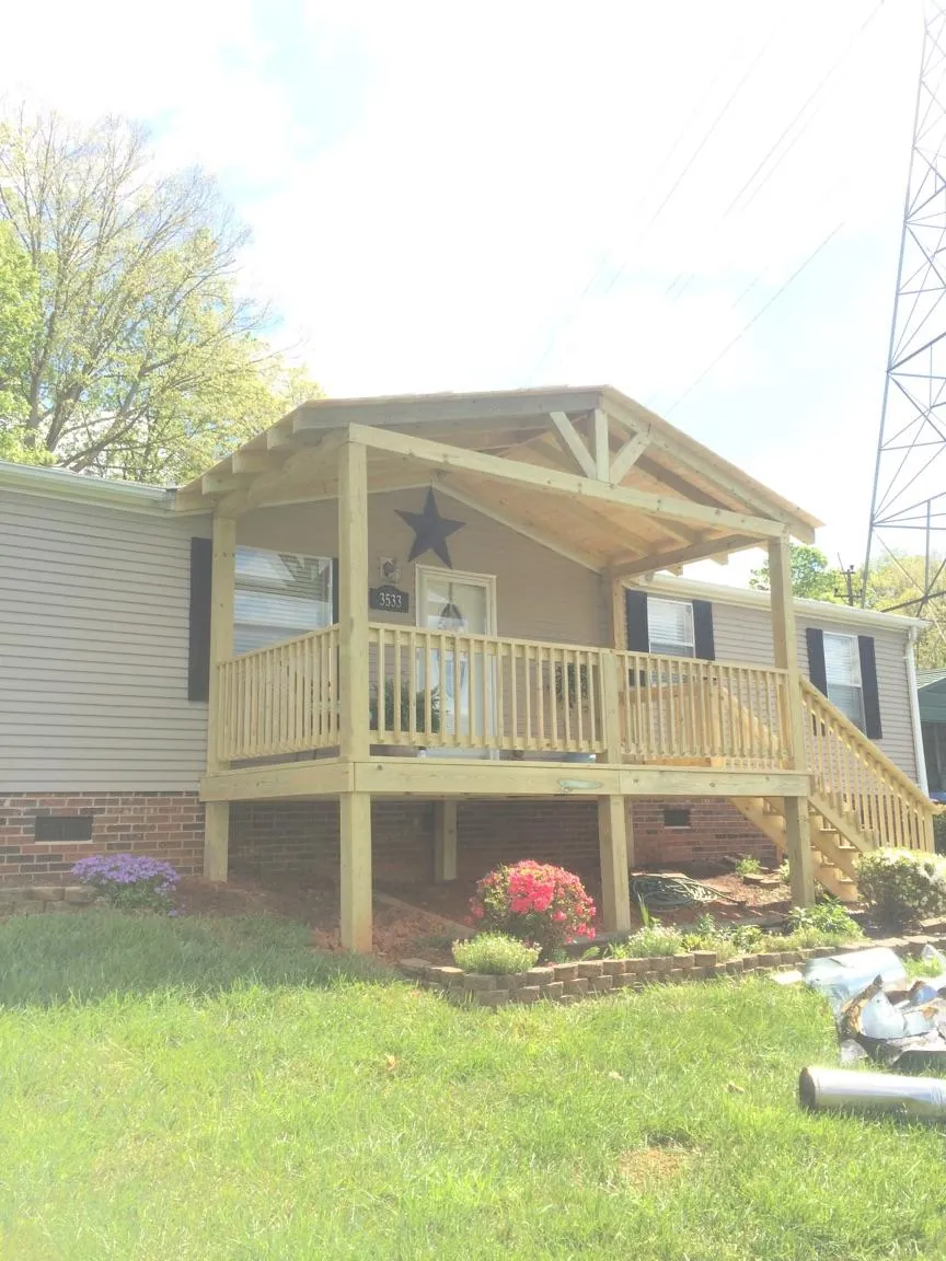 New gabled porch roof and deck railing added to a ranch home in Rock Creek